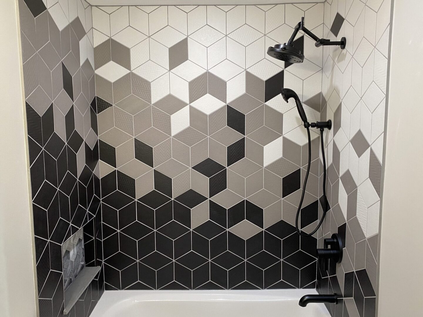 Modern shower with black tile accents.